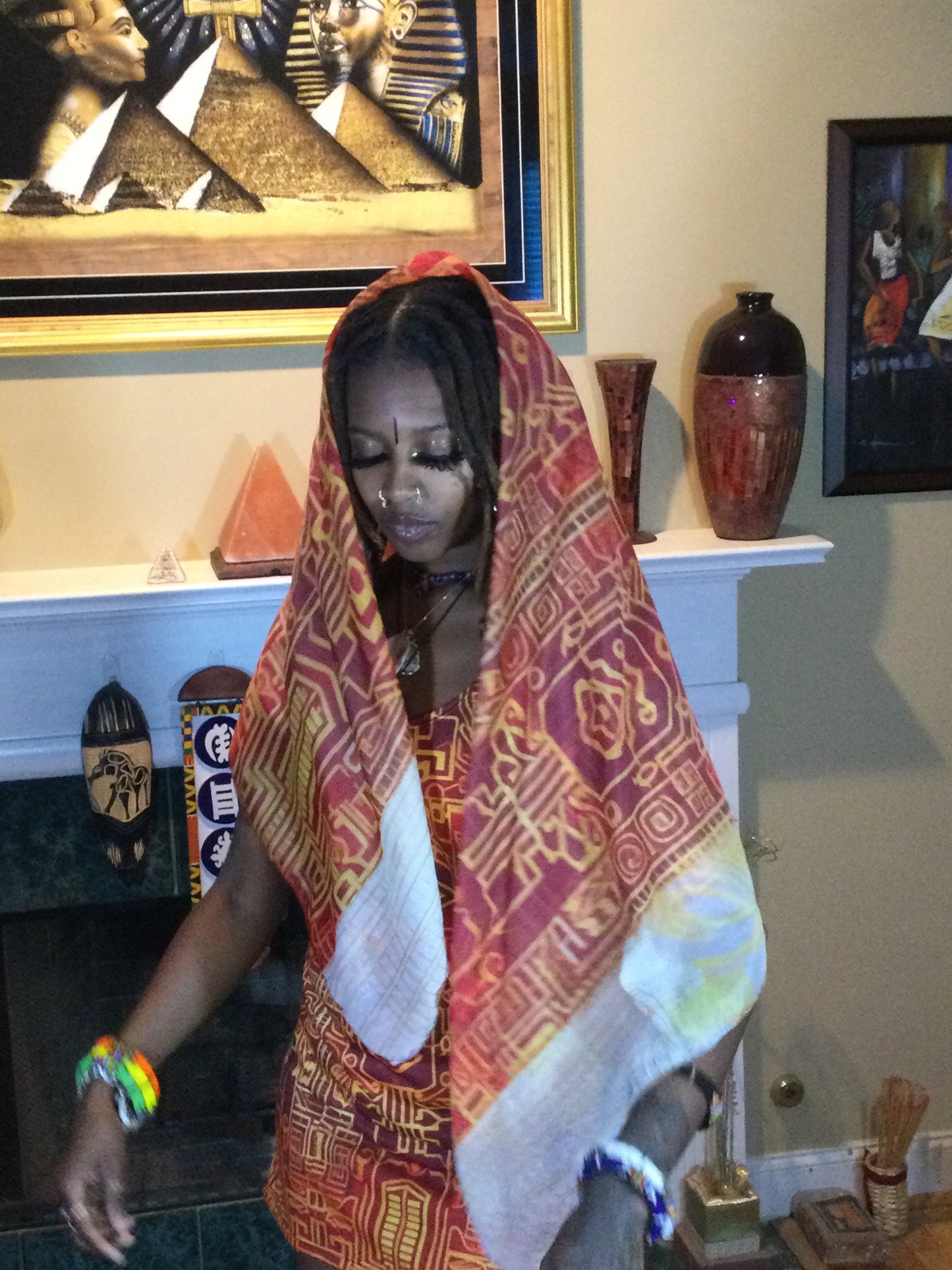 Black woman wearing Afrofuturistic Kente Scarf draped on her head.