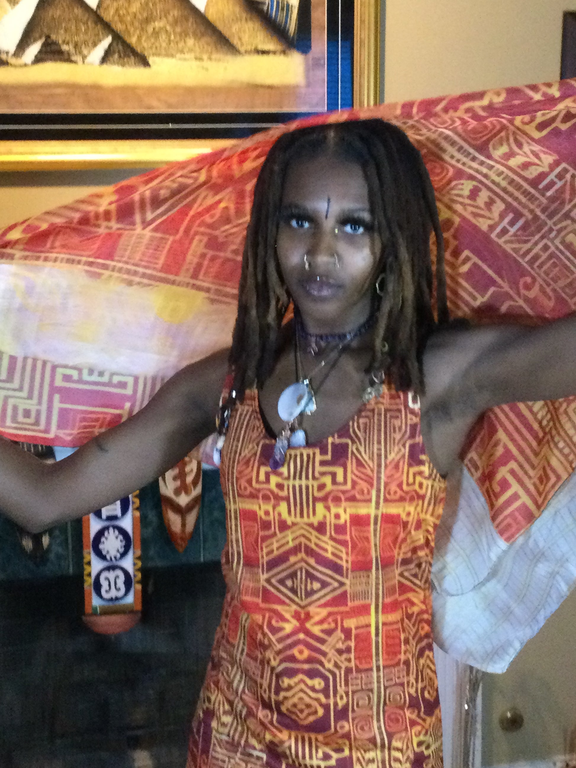 Black Woman Wearing a Afrofuturistic Kente Scarf on her loc'ed hair