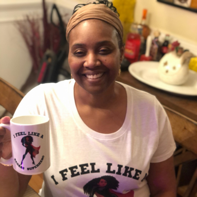 Alicia McCalla holding Badass Superhero Mug and Wearing T-Shirt