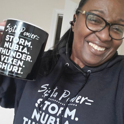 Woman holding mug wearing Sista Power Sweatshirt and Holding Mug Storm, Nubia, Thunder, Vixen and Shuri